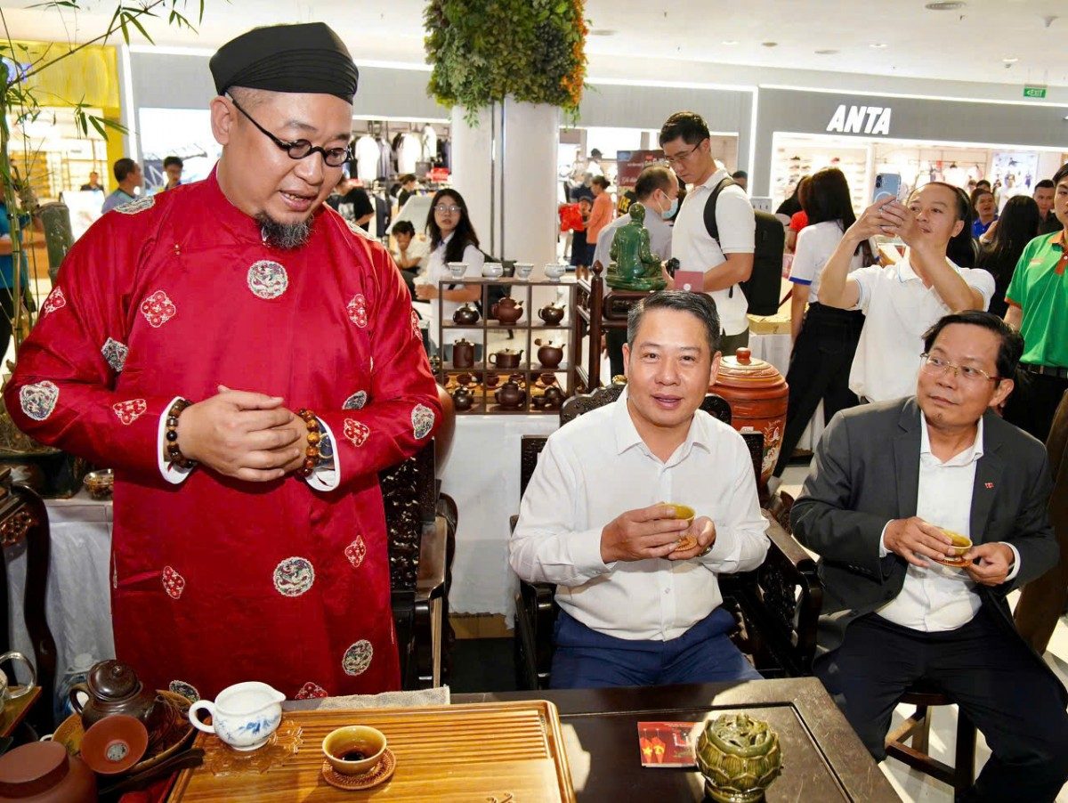 Mr. Vu Van Thuy, Head of the Southern Representative Office of the Ministry of Agriculture and Environment (in white shirt), and Journalist - Dr. To Dinh Tuan, Editor-in-Chief of Nguoi Lao Dong Newspaper, enjoying tea brewed by an artisan - Photo: NLD